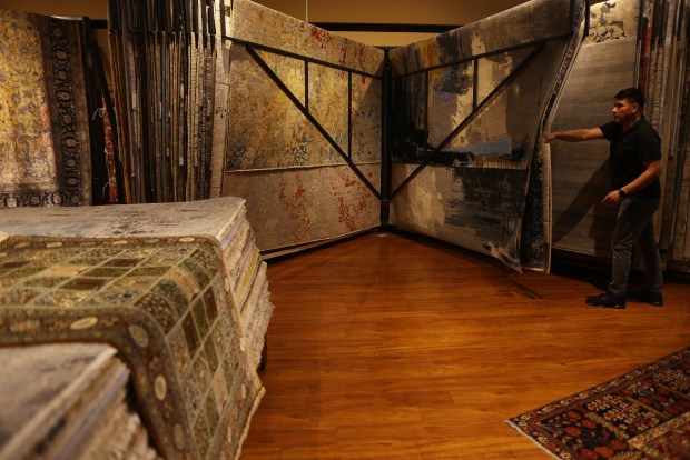 A worker moves rugs displayed at Serapi Rug Gallery on Wednesday, Sept. 24, 2025, in Los Gatos, Calif. (Aric Crabb/Bay Area News Group)