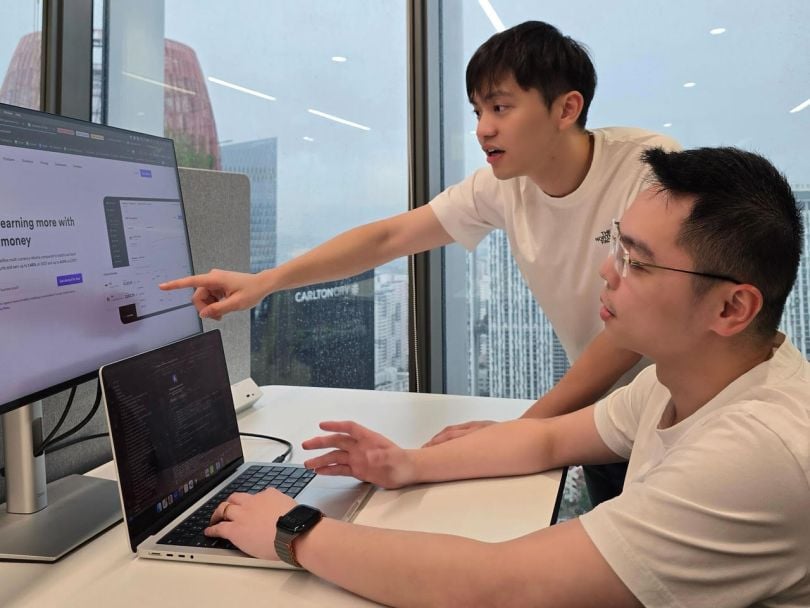 Two Airwallex team members view information on a computer screen in the company’s office