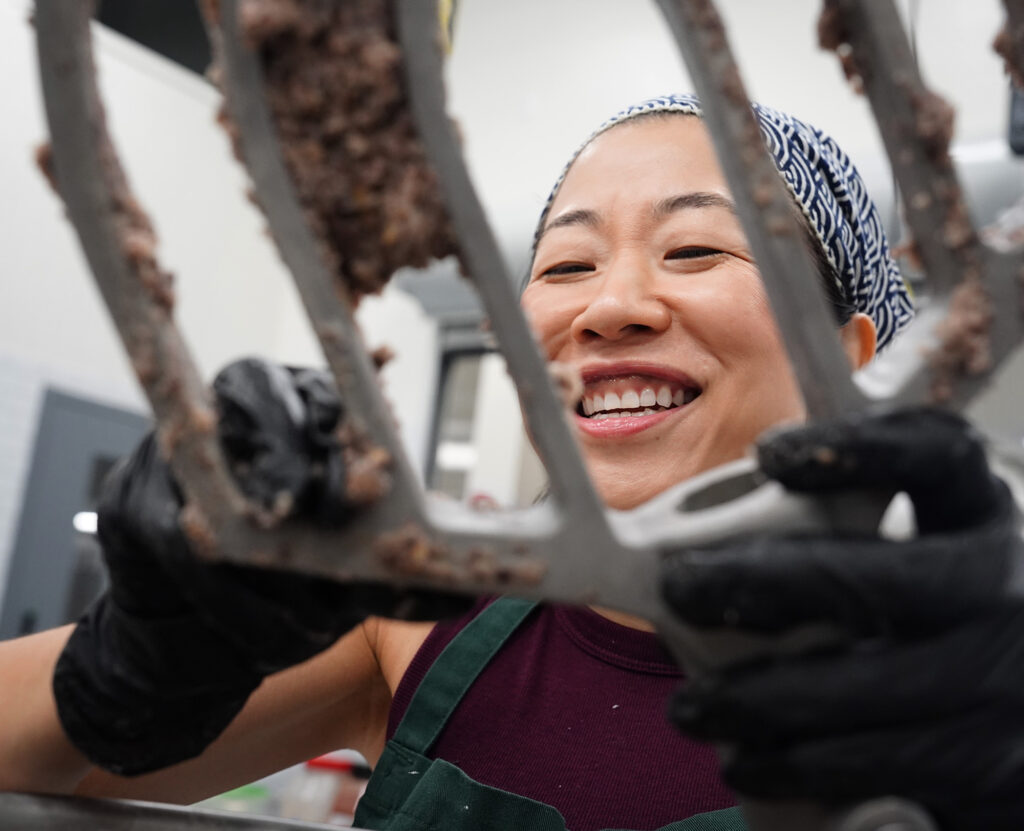 Jina Wye scrapes off limu-cracker batter from an industrial mixer at the Wahiawā Value-Added Product Development Center Wednesday, Sept. 17, 2025, in Wahiawā. The center makes producing her “Made in Hawaiʻi” crackers easier with facilities and amenities usually owned by mass-production companies. (Kevin Fujii/Civil Beat/2025)