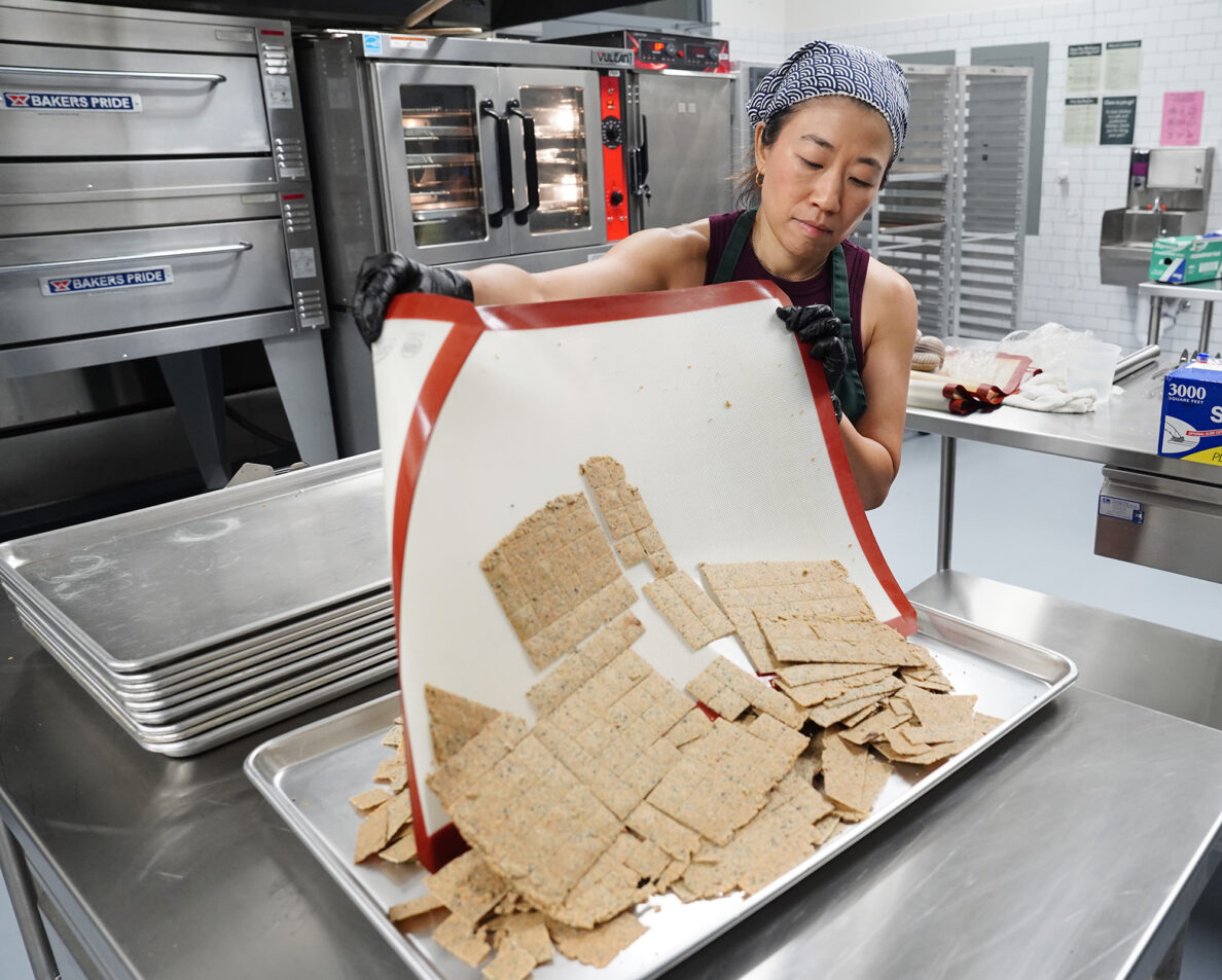 Jina Wye slides her limu crackers off a baking mat at the Wahiawā Value-Added Product Development Center Wednesday, Sept. 17, 2025, in Wahiawā. The center makes producing her “Made in Hawaiʻi” crackers easier with facilities and amenities usually owned by mass-production companies. (Kevin Fujii/Civil Beat/2025)