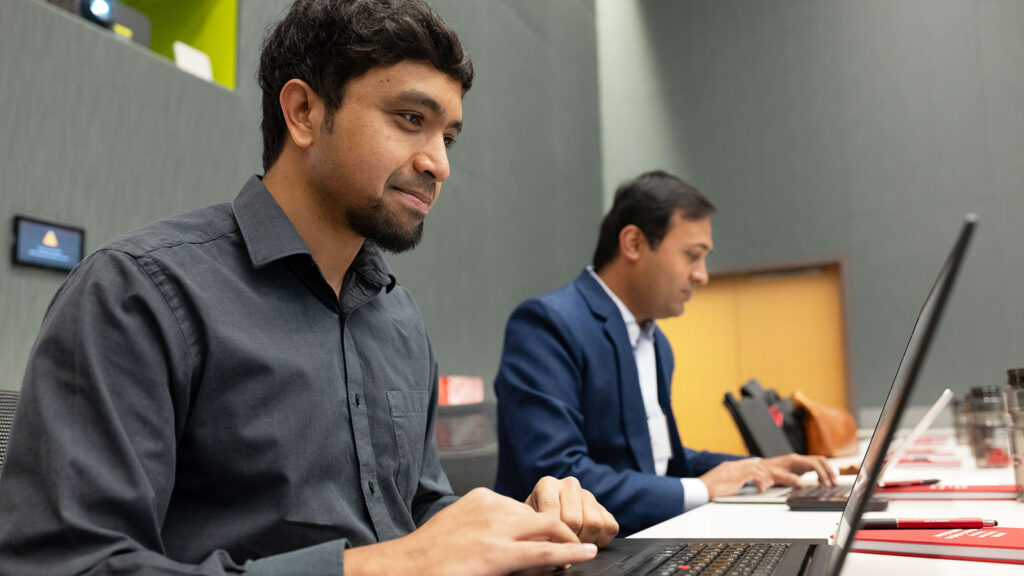 Two men on laptop computers