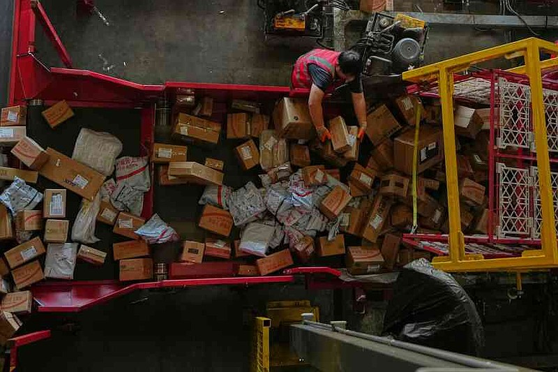 A worker sorts out parcels at a distribution center for e-commerce platform JD.com, in Beijing, Tuesday, Nov. 11, 2025.