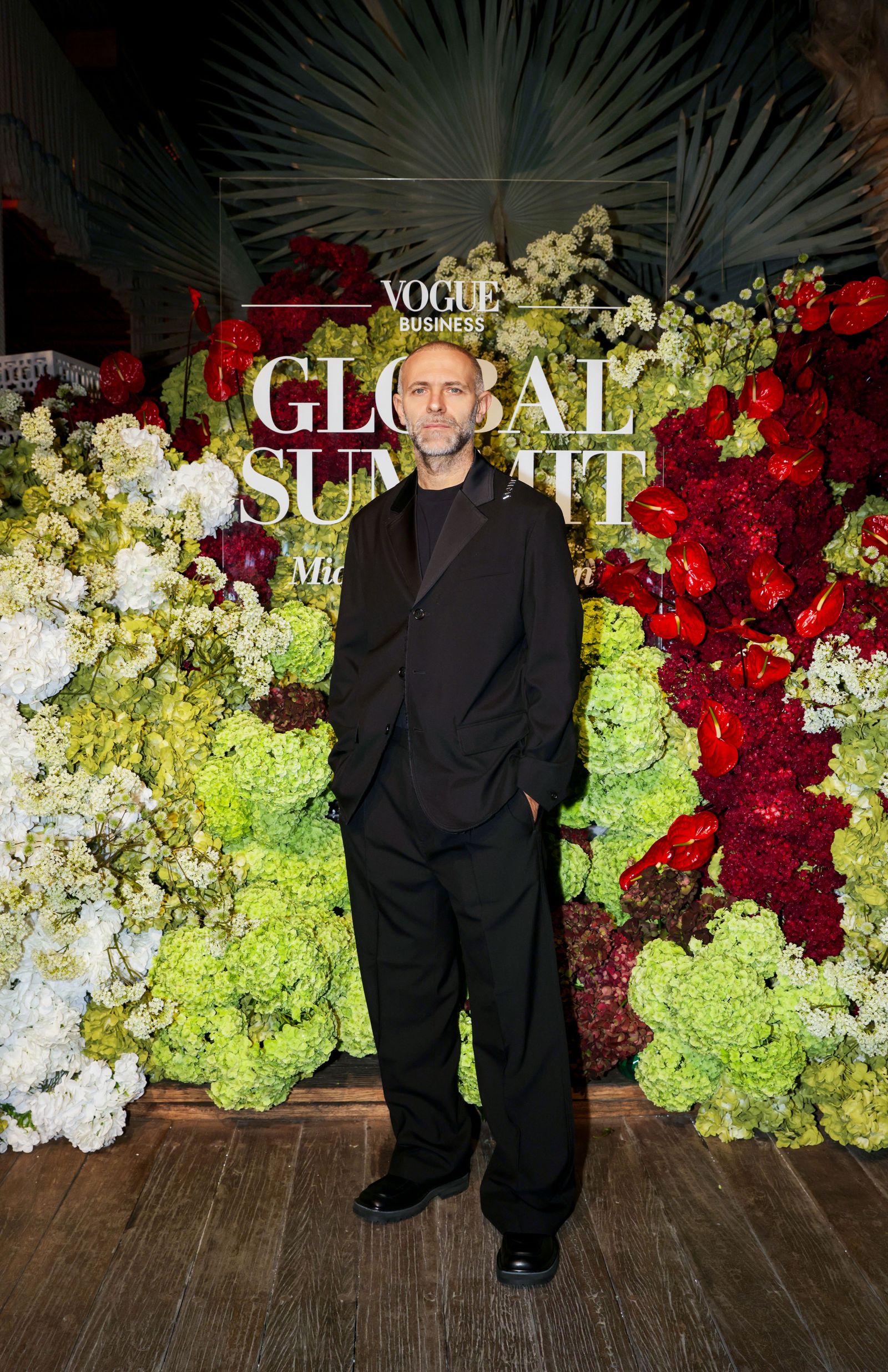 Image may contain Person Standing Adult Clothing Formal Wear Suit Face Head Photography Portrait and Flower