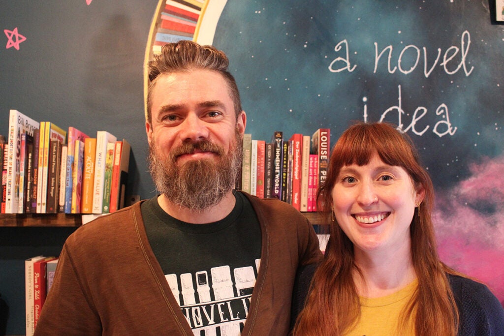 Alexander Schneider, left, and Christina Rosso-Schneider, right, co-owners of A Novel Idea on Passyunk, smile at the camera