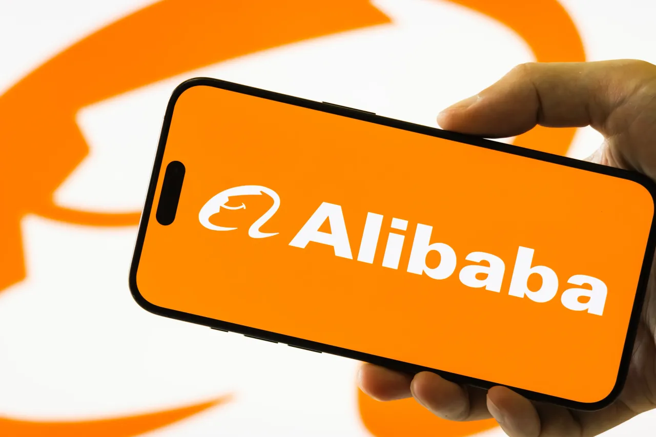 A person holds a smartphone displaying the logo of Alibaba Group. CEO Eddie Wu said the company will increase investment in AI. (Photo by Cheng Xin/Getty Images)
