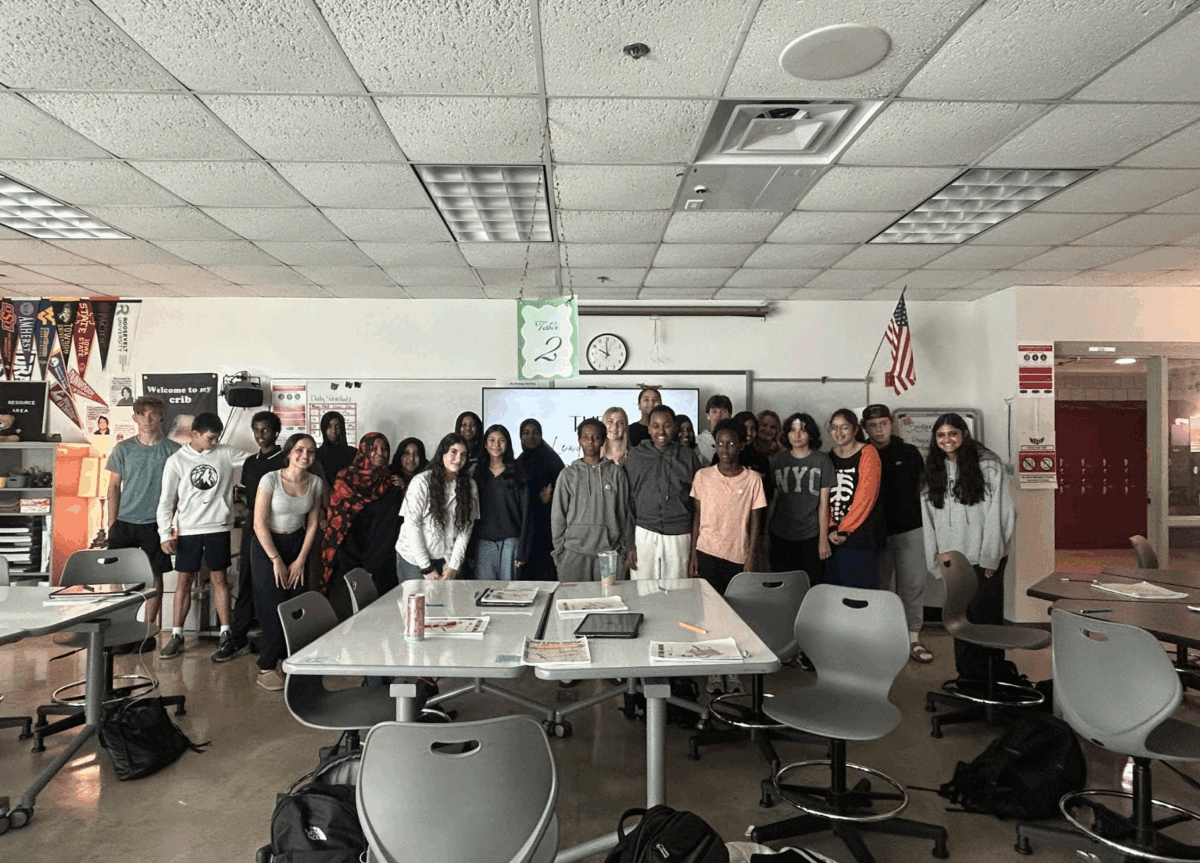 Students in Eden Prairie High School's Advancement Via Individual Determination class smile in their classroom.