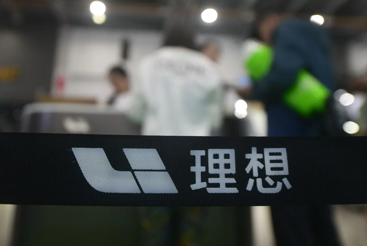 People stop by the booth of the Chinese carmaker Li Auto during an auto show in Hangzhou. (Photo credit should read LONG WEI / Feature China/Future Publishing via Getty Images)