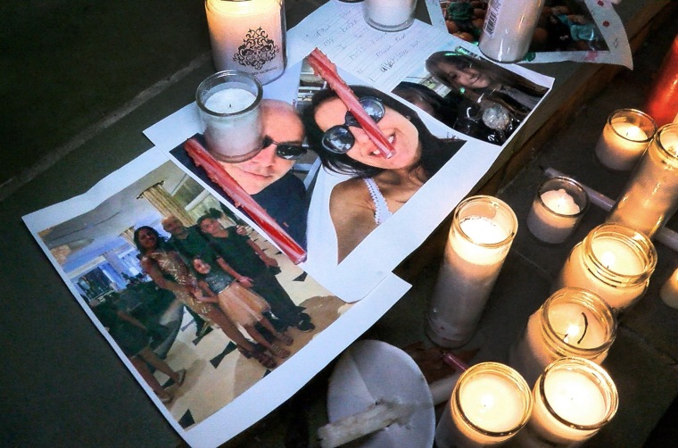 Photos of Keith Caneiro, his wife Jennifer, and children Jesse and Sophia are shown under candles during a vigil held outside