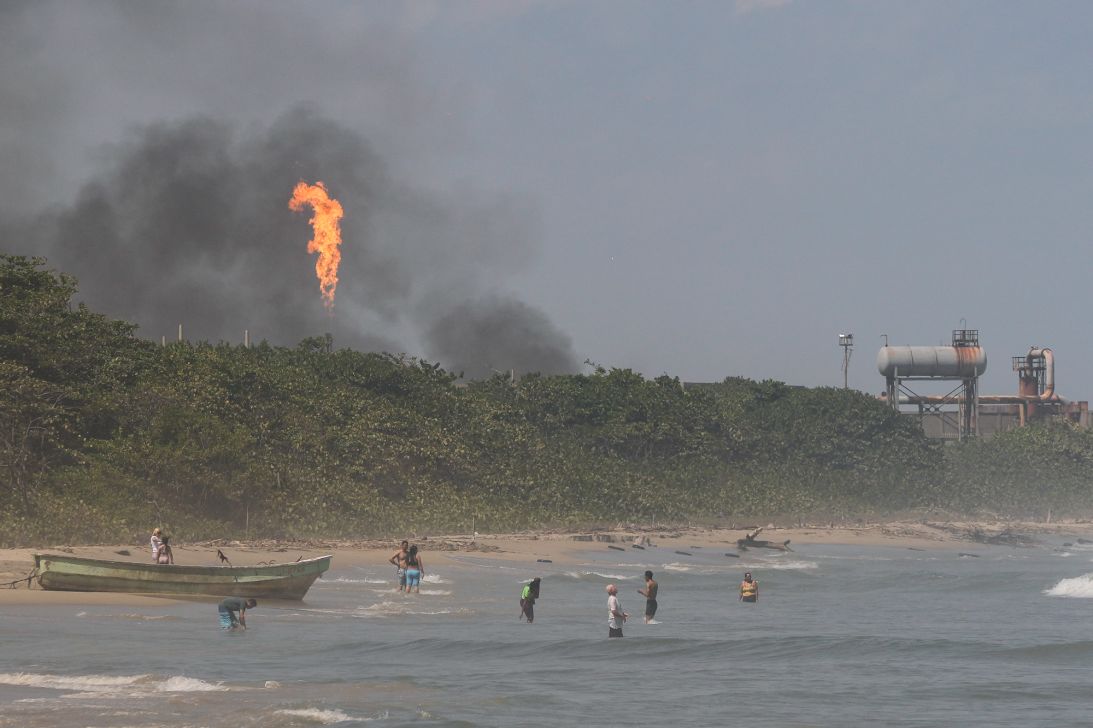 People swim near the El Palito oil refinery near Puerto Cabello, Venezuela, Monday, Jan. 29, 2024.