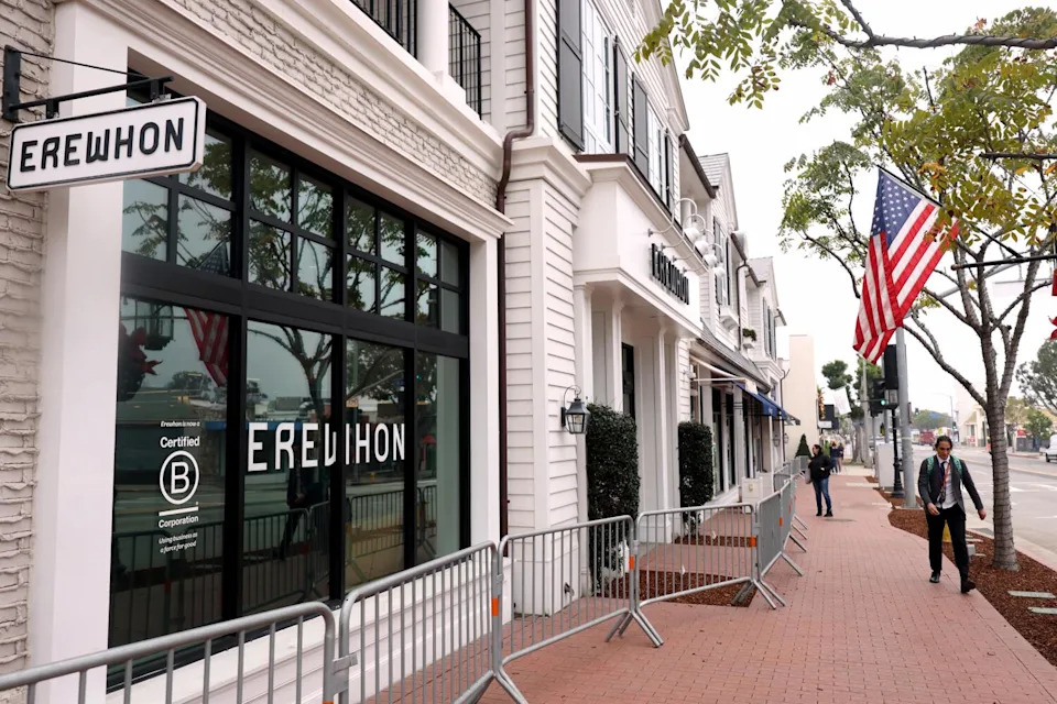Pedestrians walk past the Erewhon market in Palisades Village that plans to reopen this year.