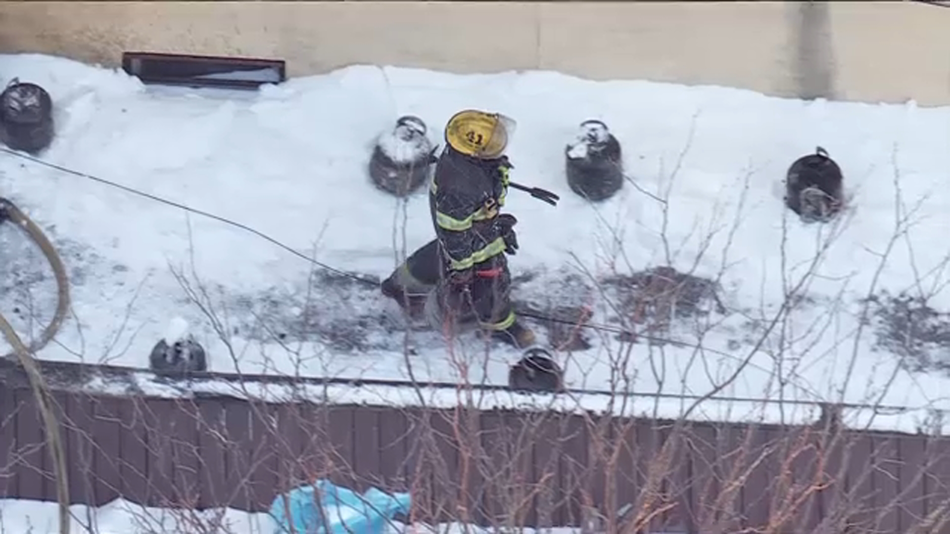 Firefighters remove several propane tanks that caught on fire outside of a business in Philadelphia's Roxborough neighborhood.
