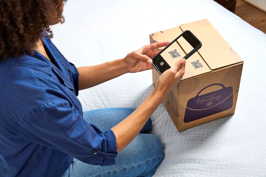 Woman scanning QR code on box.