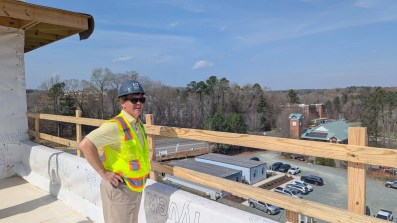 Lee Bowman of the Legion Company speaks to a group touring the 95 Market building's completed structure. This is where tenants will have a rooftop patio, which overlooks part of the South Creek neighborhood and toward downtown Chapel Hill. (Photo by Brighton McConnell/Chapel Hill Media Group.)