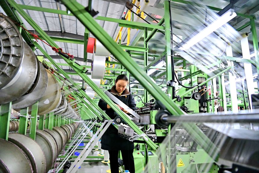 An employee works at the spinning workshop of a polyester fiber factory in Jiujiang, China, on January 16, 2024.