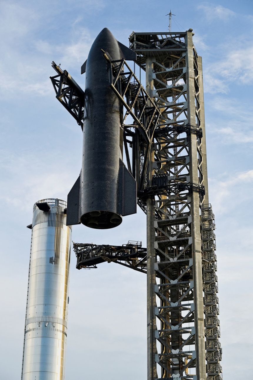 The SpaceX Starship spacecraft is hoisted along the launch tower for stacking atop the heavy booster in preparation for its 10th test flight from the company's complex in Starbase, Texas, on August 23, 2025.